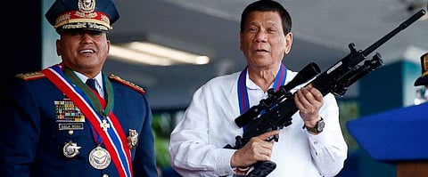 Philippine President Rodrigo Duterte, right, jokes to photographers as he holds an Israeli-made Galil rifle which was presented to him by former Philippine National Police Chief Director General Ronald 'Bato' Dela Rosa. (Photo | AP)