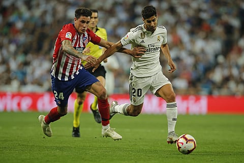 Real Madrid's Marco Asensio (R) vies for the ball with Atletico Madrid's Jose Maria Gimenez during their Spanish La Liga match | AP