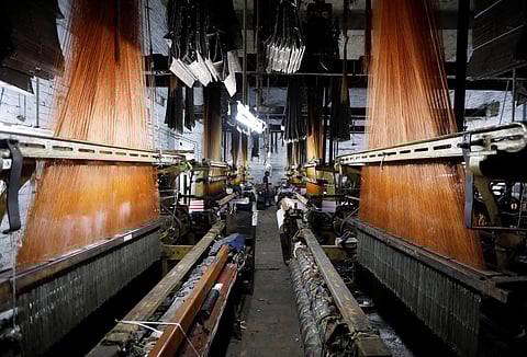 A labourer works on a powerloom machine inside a weaving factory in Panipat in the northern state of Haryana, India, August 29, 2018. | Reuters