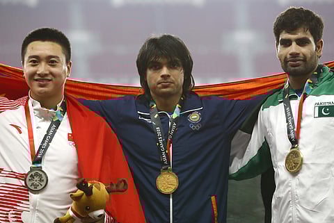Men's javelin gold medalist India's Neeraj Chopra centre stands with silver medalist China's Liu Qizhen left and bronze medalist Pakistan's Arshad Nadeem on the podium during the athletics competition at the 18th Asian Games in Jakarta. | AP
