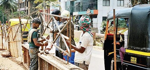 Workers placing barricades at the work site near Desai Circle in Hubballi on Friday; Abdul Maniyar being pulled out of the pit | D Hemanth