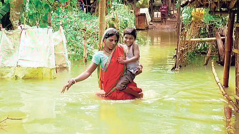 A mother carrying her child to a safer place at Biripata village under Dasarathpur block in Jajpur district on Saturday | Akshya Rout