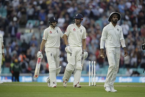 England's Joe Root, left, and England's Alastair Cook, in his last ever batting innings before retiring from test cricket, walk off at the end of the day's play during the fifth cricket test match of a five match series between England and India at the Ov