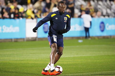 Usain Bolt warms up before a friendly trial match between the Central Coast Mariners and the Central Coast Select in Gosford, Australia, Friday, Aug. 31, 2018. | AP