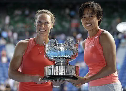 Zhang Shuai, right, and Samantha Stosur pose for a photo with their trophy after winning the women's doubles final against Kristina Mladenovic and Timea Babos at the Australian Open in Melbourne. | AP