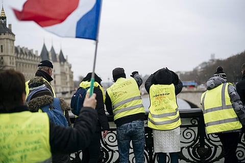 Demonstrators wearing their yellow vests stand on a bridge over the Seine river during a protest in Paris, Saturday, Jan. 5, 2019. (Photo | AP)