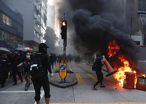 Anti-government protesters set fire to block traffic in Hong Kong. (Photo|AP)