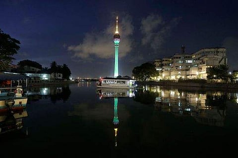 A ferry berths as a partially illuminated Colombo Lotus Tower. (Photo| AP)