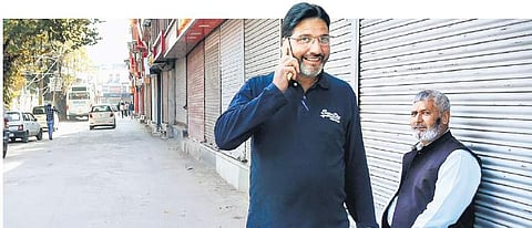 A man speaks to his relatives as he walks in Srinagar on Monday, when postpaid connections were restored in Kashmir. (Photo | PTI)