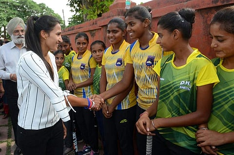 Indian national hockey captain Rani Rampal (2L) greets youth field hockey players during her visit to the Khalsa Hockey Academy in Amritsar. (Photo | AFP)