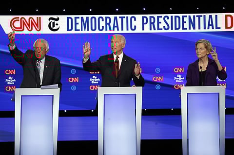 Democratic presidential candidate Sen. Bernie Sanders, I-Vt., left, former Vice President Joe Biden, center, and Sen. Elizabeth Warren, D-Mass., raise their hands to speak during a Democratic presidential primary debate hosted by CNN/New York Times at Ott