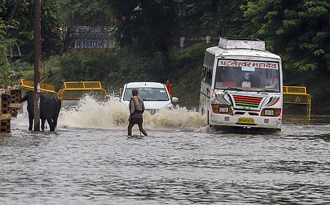 Vehicles ply on a waterlogged road following heavy rains in Prayagraj, UP. (Photo | PTI)
