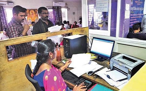 A help desk employee explaining about the new system to visitors at the  Sub-Registrar Office at Super Bazaar, Vizag, on Saturday | Express