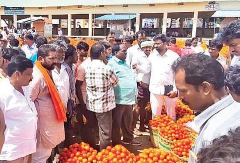 Agriculture marketing regional joint director Sudhakar monitoring the sale of tomatoes at Pathikonda Market Yard in Kurnool district on Saturday I Express