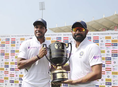 India's Mohammed Shami, right, and Umesh Yadav pose with the winners trophy. (Photo | AP)