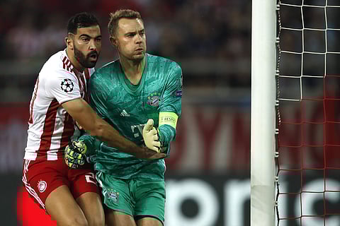 Olympiakos' Yassine Meriah, left, blocks Bayern's goalkeeper Manuel Neuer. (Photo | AP)