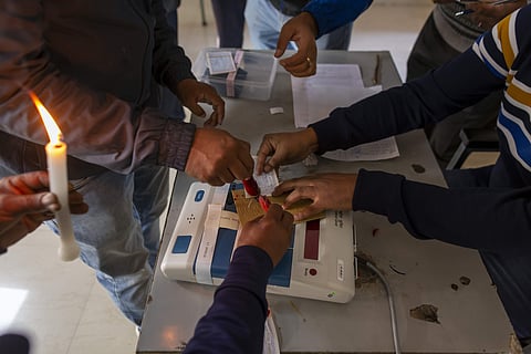 Election officials and observers seal a polling apparatus at a polling booth. (Photo | AP)