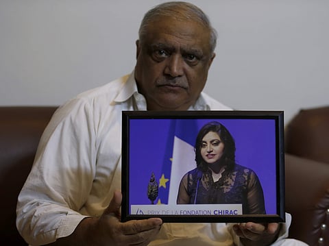 Professor Mohammad Ismail, father of a Pakistani human rights activist Gulalai Ismail, holds a picture of his daughter as he poses for a photo, in his home in Islamabad (File photo| AP)