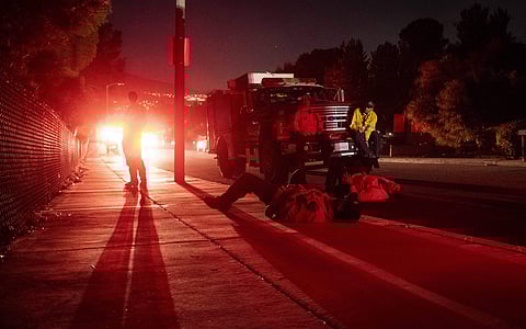 Firefighters from Orange County await further instructions in a blackout during the Tick Fire in in Santa Clarita (Photo| AP)