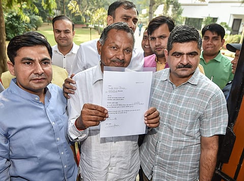 Haryana Independent MLA Dharampal Godar shows his letter of support that he handed over to BJP after meeting party's Working President JP Nadda. (Photo | PTI)
