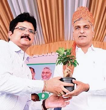 Collector M Hanumantha Rao presents a sapling to Finance Minister T Harish Rao