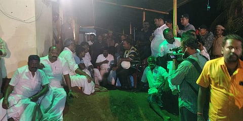 TN Deputy CM O Panneerselvam sits with Sujith's family to monitor the rescue operation. (Photo | EPS)