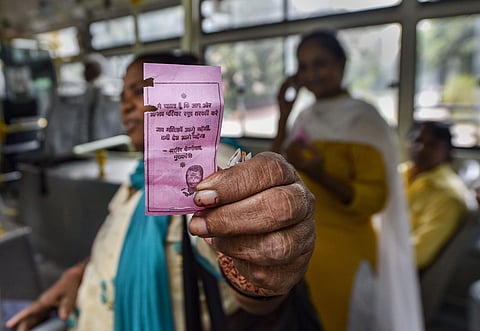 A woman shows the 'pink ticket' during her ride on a DTC Bus in New Delhi. (Photo | PTI)
