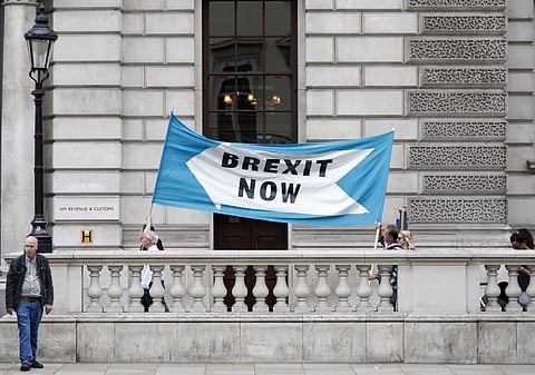 Pro Brexit demonstrators parade their banner past the Treasury building in London. (File Photo | AP)
