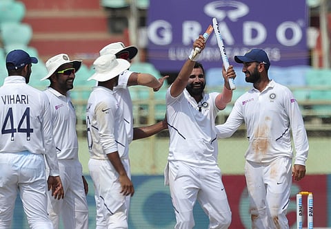 Indian bowler Mohammed Shami, with out cap, celebrates by showing broken wicket after dismissing South Africa's Dane Piedt. (Photo | AP)
