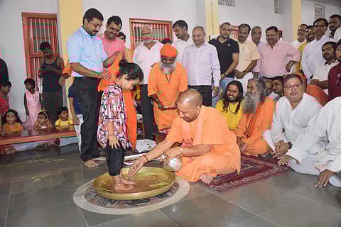 Uttar Pradesh Chief Minister Yogi Adityanath washes the feet of a young girl as part of 'Kanya Pujan' (Photo | PTI)