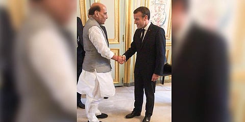 Union Defence Minister Rajnath Singh shakes hands with French President Emmanuel Macron in Paris. (Photo|PTI)