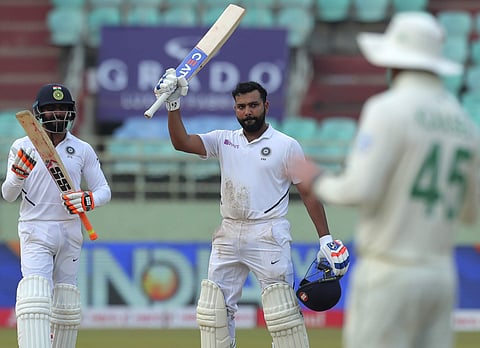 India's Rohit Sharma, center, raises his bat after scoring a century (Photo | AP)
