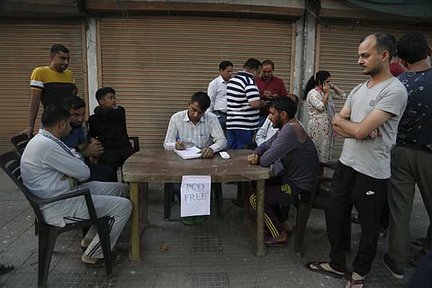 Kashmiris wait to register their numbers before calling from a free public telephone provided by paramilitary soldiers for civilians, outside their base camp in Srinagar (File photo| AP)