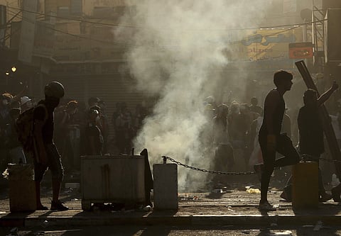Iraqi riot police fire tear gas to disperse anti-government protesters during ongoing protests in central Baghdad, Iraq, Saturday, Nov. 9, 2019. The protests intensified Saturday afternoon as demonstrators tried to reach the three bridges, hours after bei