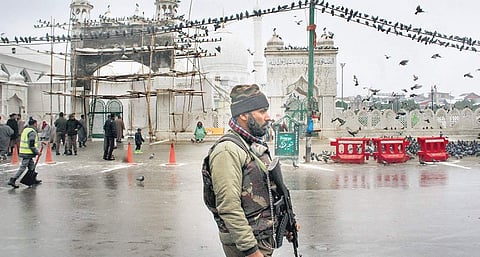 Security stands by at Hazratbal shrine during celebration, of Eid-e-Milad (L), Devotees pray as they get a glimpse of the holy relic | PTI