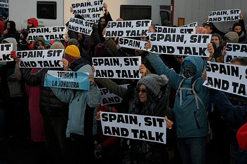 Protesters hold banners reading 'Spain sit and talk' as they block the AP-7 highway at the Spanish-French border in La Jonquera northern Spain, on November 11, 2019 during an action called by Tsunami Democratic movement for civil disobedience actions. Cat