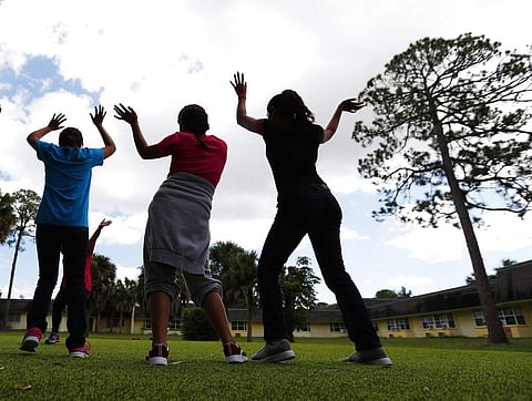 Girls dance as they do exercises at a shelter for migrant teenage girls. (Photo | AP)