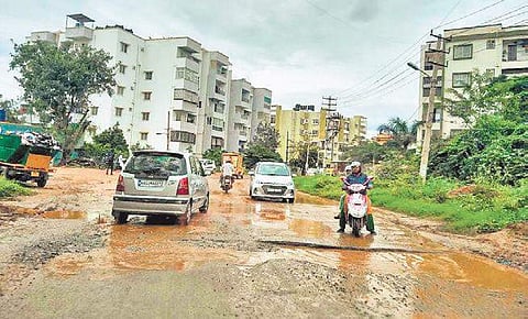 Motorists have a rough ride on a stretch in Belathur; (below) a car is stuck in dent on the road| Express