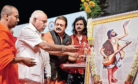 Chief Minister B S Yediyurappa offers flowers to a painting of philospher and poet Kanakadasa at Ravindra Kalakshetra in Bengaluru on Friday  | meghana sastry