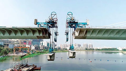 Two segments of the extradosed cable-stayed bridge being lifted across the Durgam Cheruvu in Hyderabad on Friday