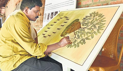 Krishna R painting a Kurumba painting