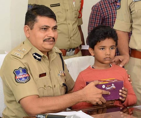 Rachakonda police commissioner Mahesh Bhagwat gifting a box of chocolates the boy who was kidnapped