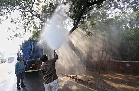 SDMC worker spray water on the tree in New Delhi on Tuesday. | (Photo | Arun Kumar/EPS)
