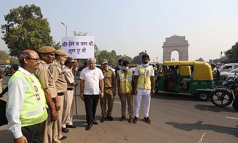 Delhi Transport Minister Kailash Gahlot with sign board requesting to Commuters to follow odd even in New Delhi on Tuesday. | (Photo | Arun Kumar P/EPS)