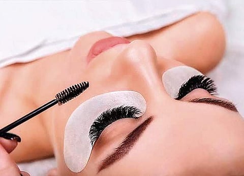 With lashes aflutter