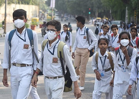 School children cover their faces to protect themselves from the toxic air in New Delhi. (Photo | Parveen Negi, EPS )
