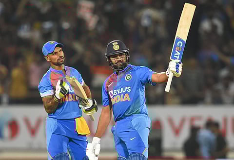 Rohit Sharma raises his bat after scoring 50 runs during the second T20 cricket match against Bangladesh at Saurashtra Cricket Association Stadium in Rajkot (Photo| PTI)