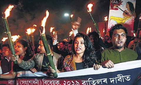 Students of Gauhati University take part in a torchlight rally against the Citizenship Amendment Bill, at Jalukbari in Guwahati on Monday | PTI