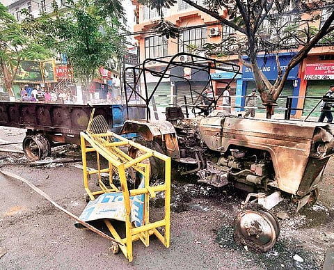 A charred tractor that was set on fire by the protesters in Guwahati (Photo | PTI)