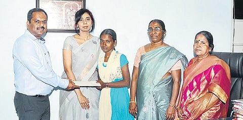 Joseph Raj, ONGC DGM (HR) hands over `65,000 to Jayalakshmi, in the presence of Pudukkottai Collector P Uma Maheshwari, on Tuesday | Express